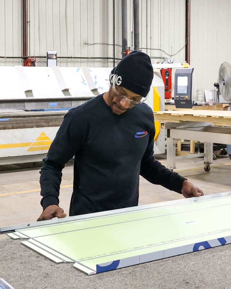 Employee Working At Table On Metal Panel